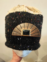 Load image into Gallery viewer, Black knitted beanie with a decorative gold emblem on a neutral background