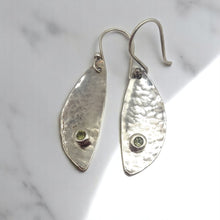 Load image into Gallery viewer, Handcrafted sterling silver earrings made from vintage spoon bowls, featuring a hammered texture and bezel-set green peridot stones, with hand-forged sterling silver hooks.
