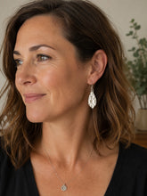 Load image into Gallery viewer, Woman wearing a silver earring and necklace indoors with a plant in the background