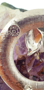 round silver brooch with leaf design showing hallmark