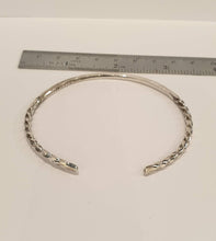 Load image into Gallery viewer, silver bangle with twisted ends against a ruler